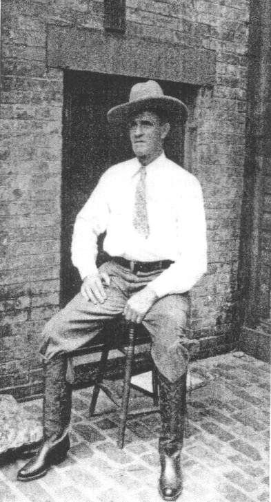 Old West imposter Frank Hopkins poses in his new boots on a milking stool in New York-
